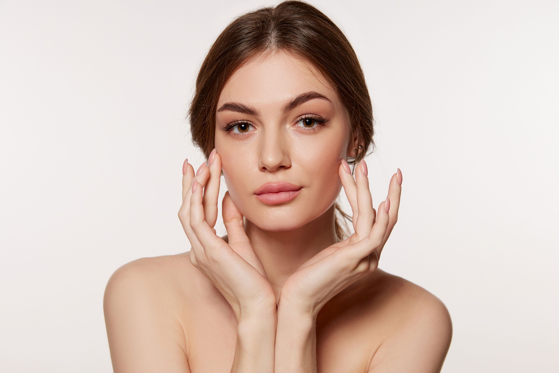 Portrait of young beautiful woman with perfect smooth skin isolated over white background. Perfect face, taking care after skin condition