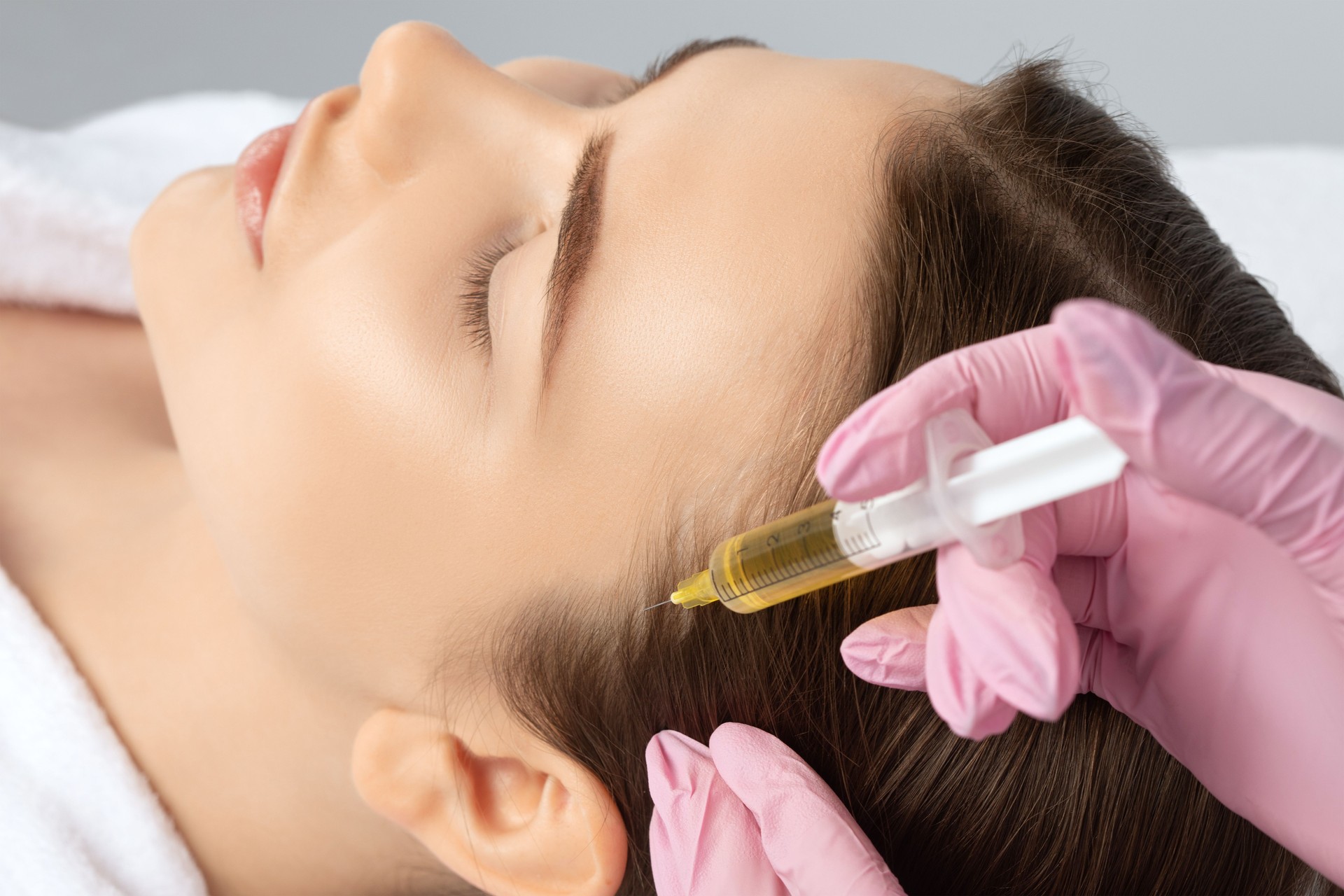 Cosmetologist does prp therapy against hair loss and anti-dandruff of a beautiful woman in a beauty salon. Aesthetic cosmetology concept, hair treatment.